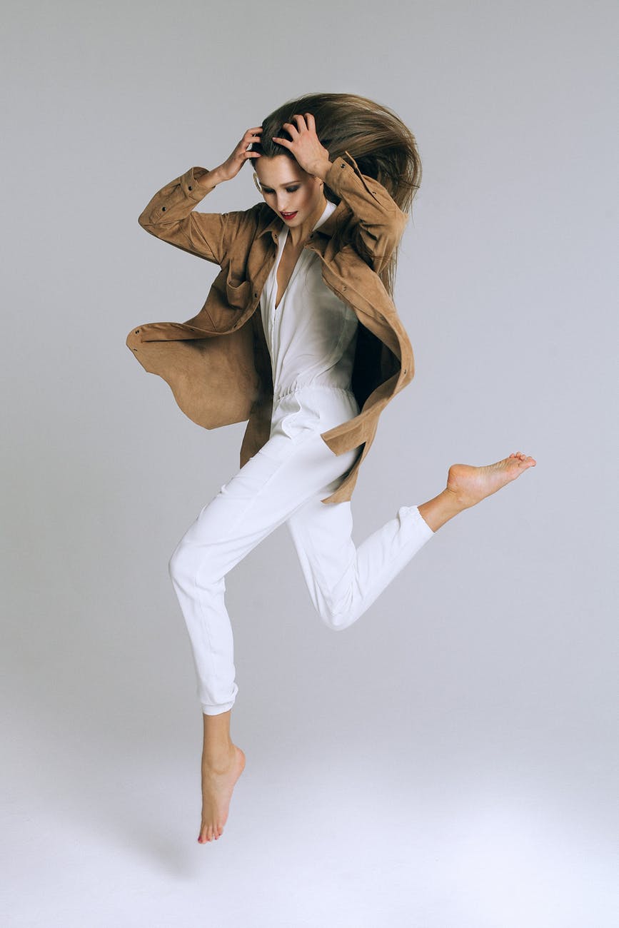 fashionable woman jumping on white background